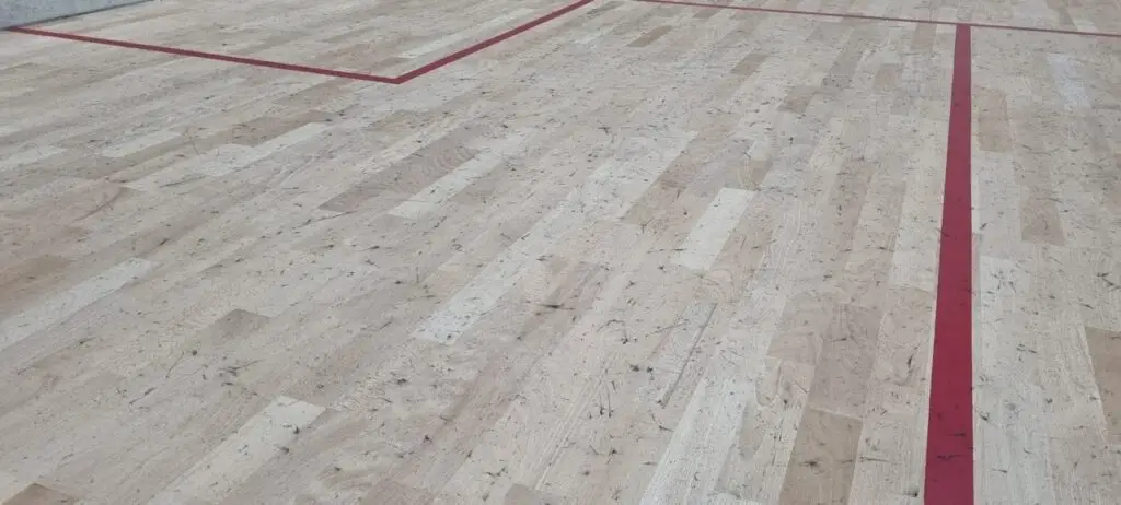 Squashboden der durch Schuhe mit schwarzen Sohlen verunreiningt ist