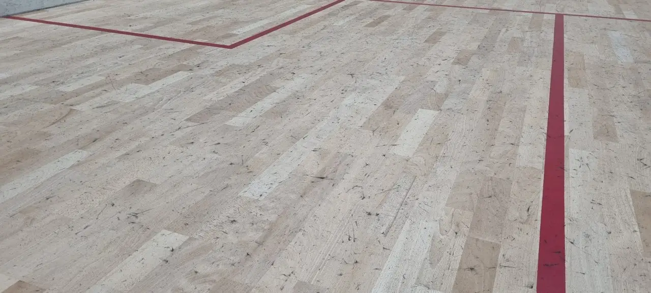 Squashboden der durch Schuhe mit schwarzen Sohlen verunreiningt ist